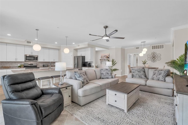 tiled living room featuring ornamental molding and ceiling fan