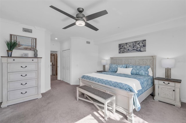 bedroom featuring a closet, ceiling fan, light carpet, and crown molding