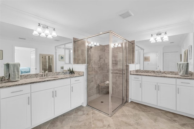 bathroom with vanity, crown molding, a shower with shower door, and tile patterned flooring