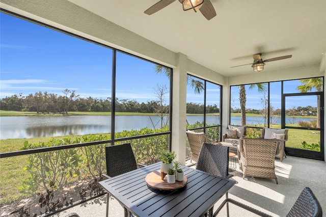 sunroom / solarium with a water view and ceiling fan