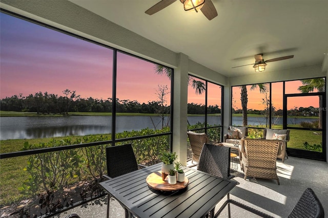 sunroom with a water view and ceiling fan