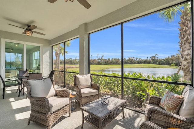 sunroom / solarium with a water view and ceiling fan