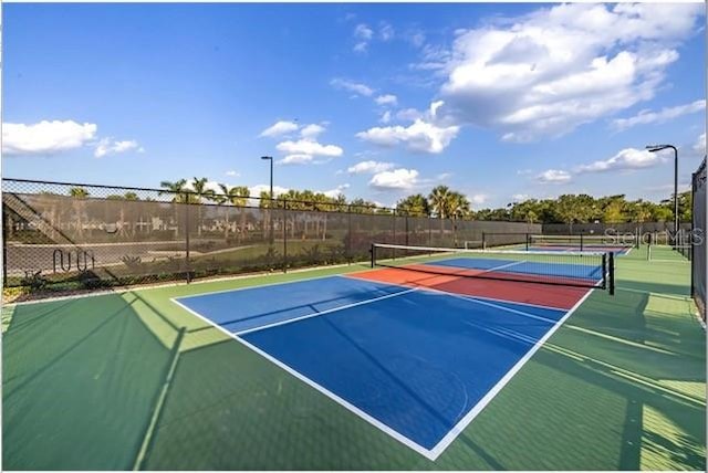 view of tennis court with basketball hoop