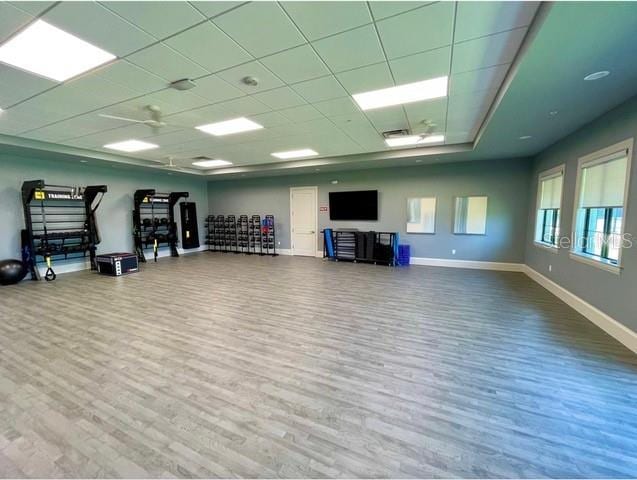 exercise room with hardwood / wood-style floors and a paneled ceiling