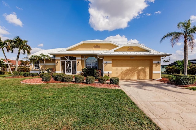 2868 Coral Way, Punta Gorda, FL 33950 - view of front of house featuring stucco siding, a garage, a front yard, a standing seam roof, and driveway