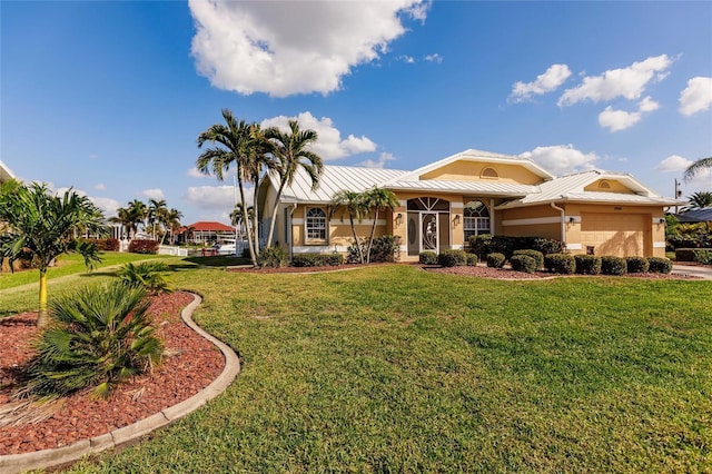 2868 Coral Way, Punta Gorda, FL 33950 - view of front of house featuring a standing seam roof, an attached garage, metal roof, a front lawn, and stucco siding