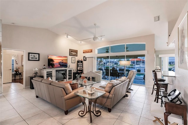 living room with ceiling fan, light tile patterned floors, and high vaulted ceiling