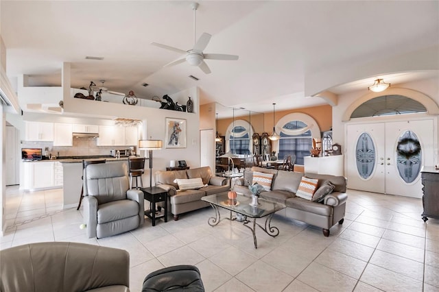 living room with light tile patterned flooring, ceiling fan, and vaulted ceiling