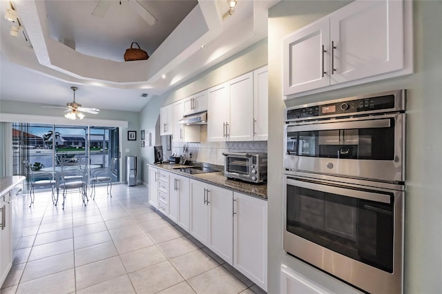 2868 Coral Way, Punta Gorda, FL 33950 - kitchen with ceiling fan, stainless steel double oven, white cabinetry, under cabinet range hood, and tasteful backsplash