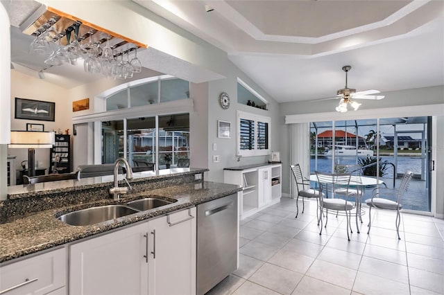 kitchen featuring dark stone countertops, white cabinetry, sink, and dishwasher