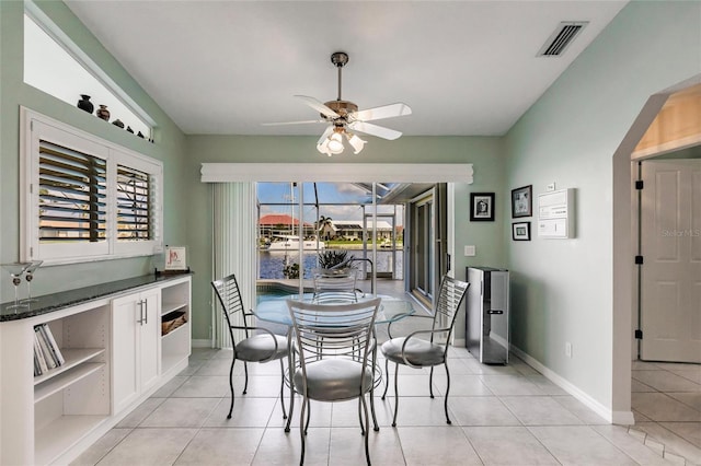 2868 Coral Way, Punta Gorda, FL 33950 - dining space with ceiling fan, light tile patterned flooring, baseboards, and a water view