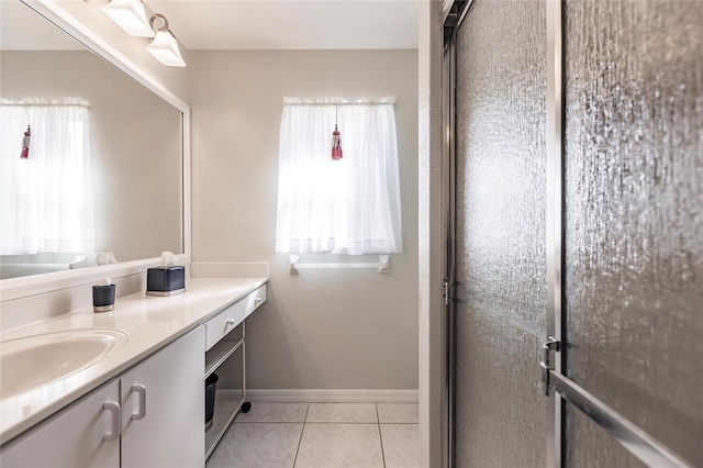 bathroom with an enclosed shower, vanity, and tile patterned floors