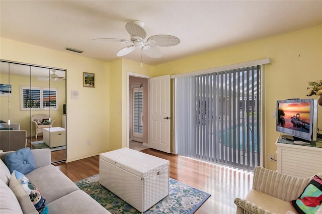 living room featuring hardwood / wood-style floors and ceiling fan