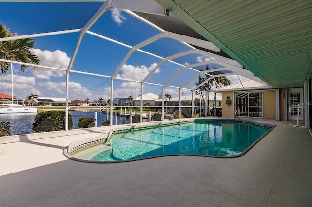 view of pool with a lanai, a water view, and a patio area