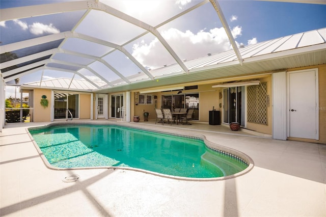 view of pool with glass enclosure, a patio, and ceiling fan