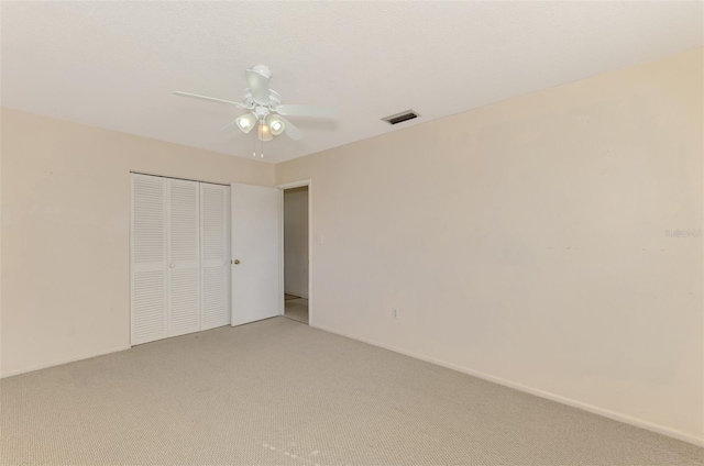 unfurnished bedroom with ceiling fan, a closet, and carpet