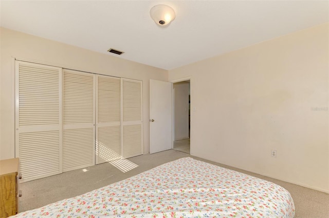 bedroom with light carpet and a closet