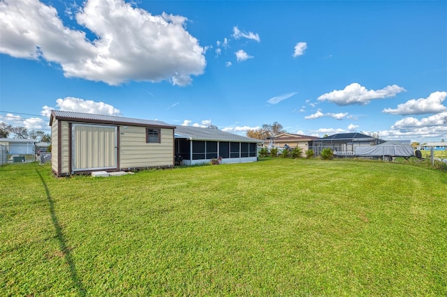 rear view of property with a lawn and a storage unit