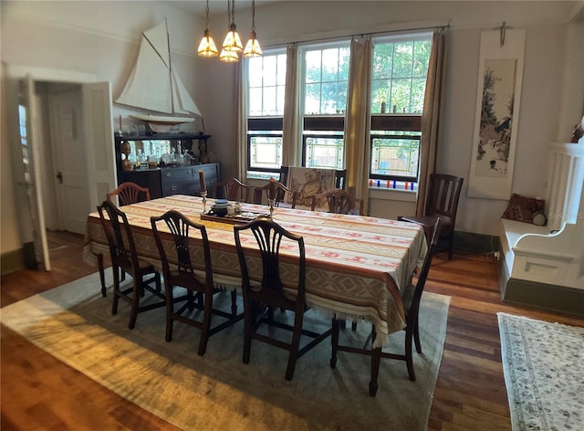 dining space featuring dark wood-type flooring and an inviting chandelier