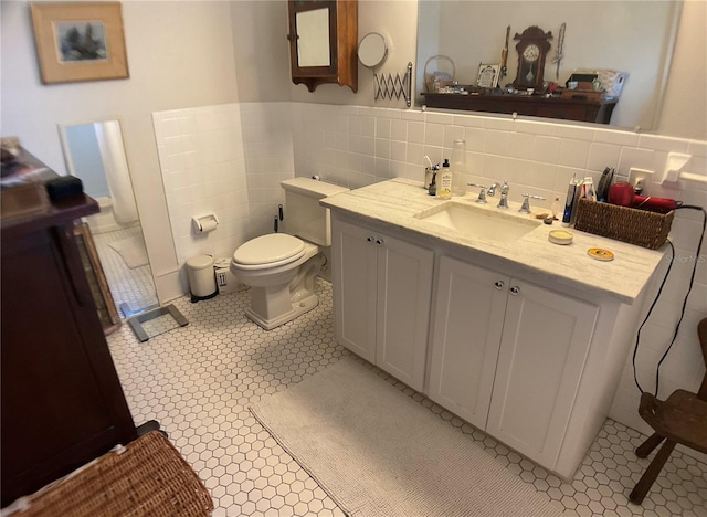 bathroom with tile walls, tile patterned floors, backsplash, vanity, and toilet