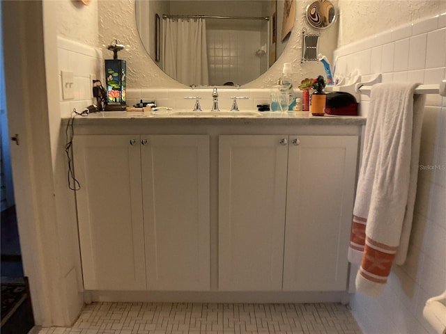 bathroom featuring walk in shower, tile walls, and vanity