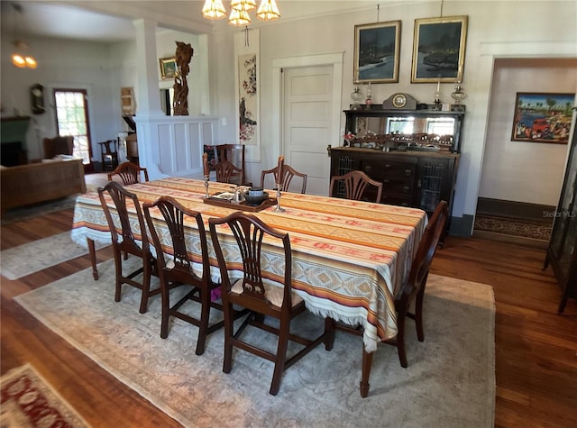 dining space featuring wood-type flooring and a notable chandelier