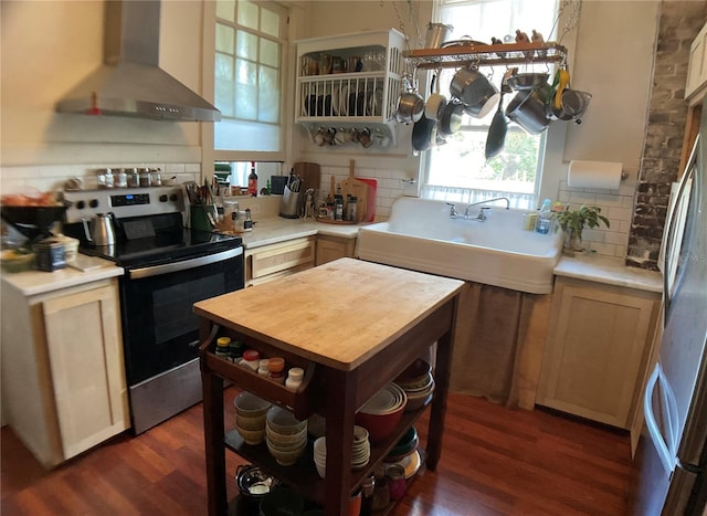 kitchen featuring decorative backsplash, dark wood-type flooring, wall chimney range hood, and electric stove