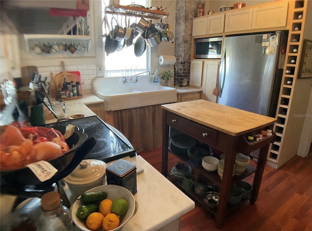 kitchen featuring stainless steel appliances, sink, light brown cabinets, dark hardwood / wood-style flooring, and decorative backsplash