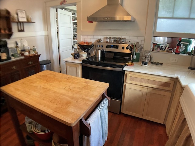 kitchen featuring dark wood-type flooring, light brown cabinetry, wall chimney range hood, and stainless steel electric stove