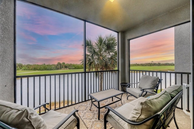 sunroom featuring a water view