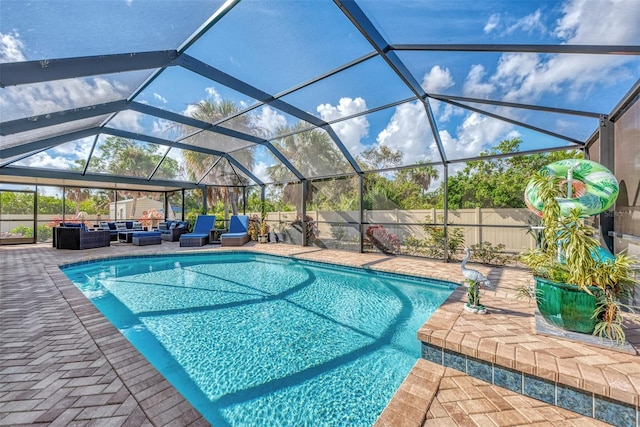 view of pool with a patio, an outdoor living space, and glass enclosure