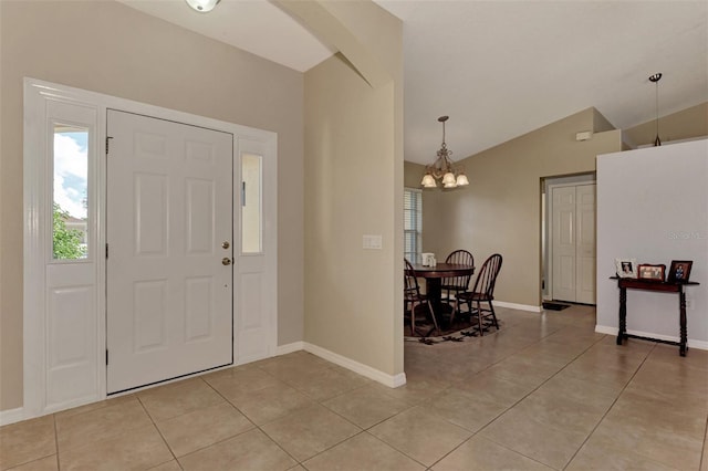 tiled foyer with lofted ceiling and a chandelier