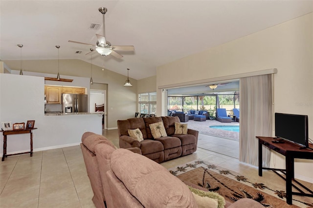 living room featuring lofted ceiling, ceiling fan, and light tile patterned floors