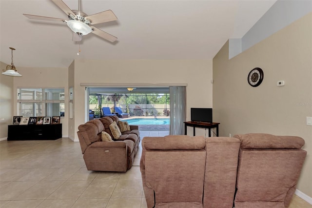 tiled living room featuring ceiling fan and vaulted ceiling