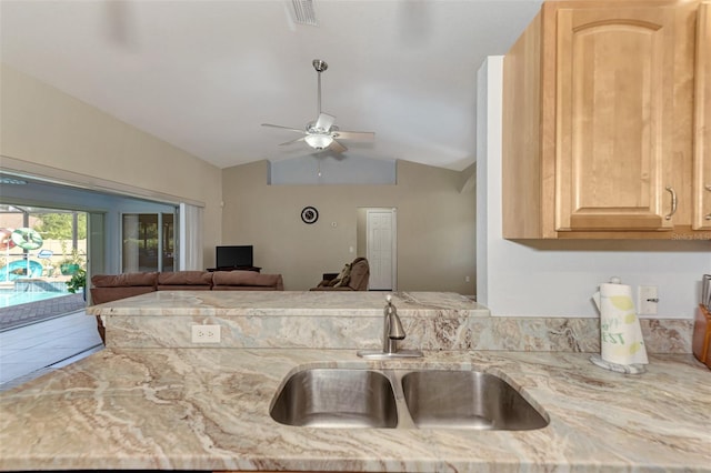 kitchen with sink, ceiling fan, light brown cabinetry, and vaulted ceiling