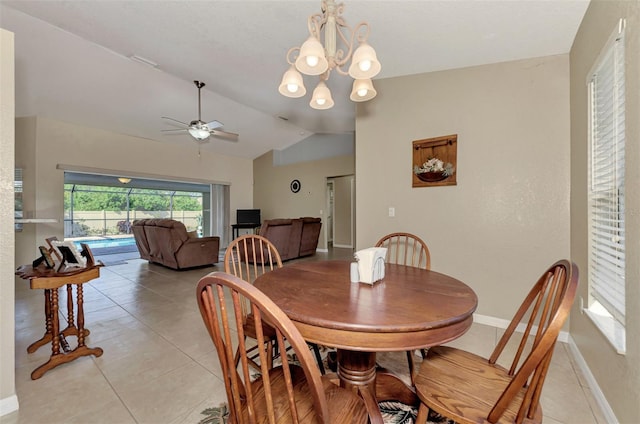 dining room with light tile patterned floors, vaulted ceiling, and ceiling fan with notable chandelier