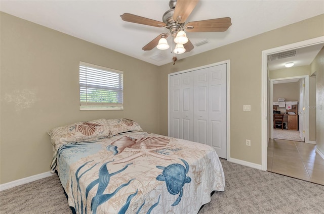 bedroom featuring light colored carpet, a closet, and ceiling fan