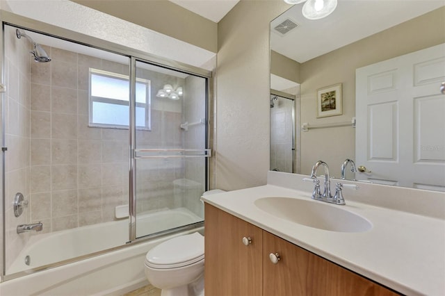 full bathroom featuring vanity, enclosed tub / shower combo, and toilet