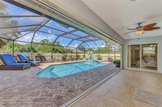 view of pool with a patio, ceiling fan, and glass enclosure