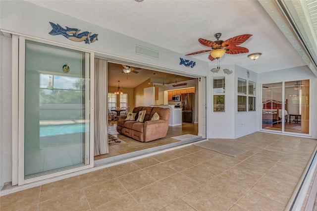 unfurnished sunroom featuring ceiling fan and vaulted ceiling