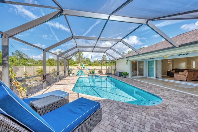 view of swimming pool featuring a patio area and glass enclosure