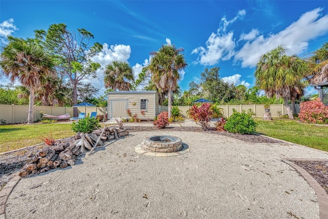 view of yard featuring an outdoor fire pit and a shed