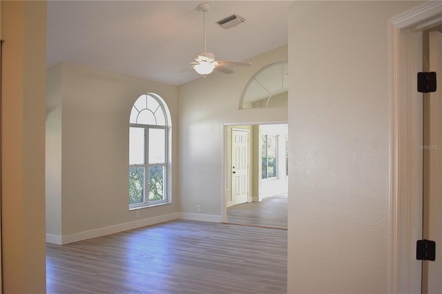 unfurnished room with wood-type flooring, ceiling fan, and lofted ceiling