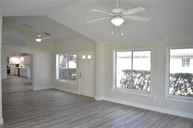 unfurnished living room with ceiling fan, wood-type flooring, and vaulted ceiling