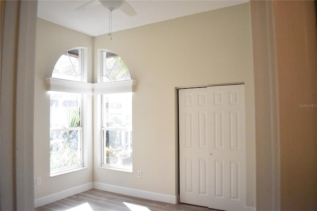 unfurnished bedroom featuring light wood-type flooring, a closet, and ceiling fan