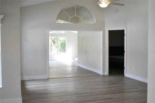 spare room with ceiling fan, dark wood-type flooring, and high vaulted ceiling