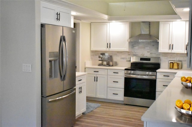 kitchen featuring white cabinetry, backsplash, wall chimney exhaust hood, and appliances with stainless steel finishes