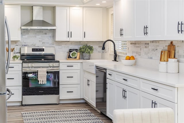 956 Harbor Town Dr, Venice, FL 34292 - kitchen featuring stainless steel appliances, wall chimney exhaust hood, white cabinetry, light wood-style floors, and recessed lighting