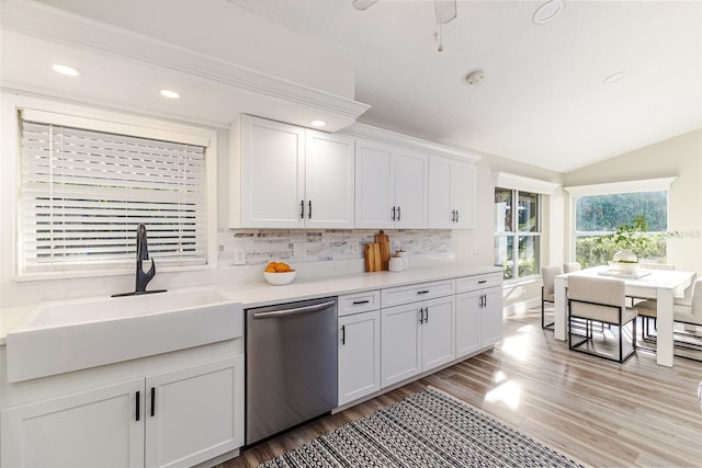 956 Harbor Town Dr, Venice, FL 34292 - kitchen featuring stainless steel dishwasher, a sink, light wood-type flooring, backsplash, and white cabinetry
