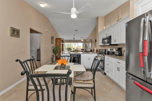 kitchen with lofted ceiling, white cabinets, kitchen peninsula, sink, and stainless steel appliances